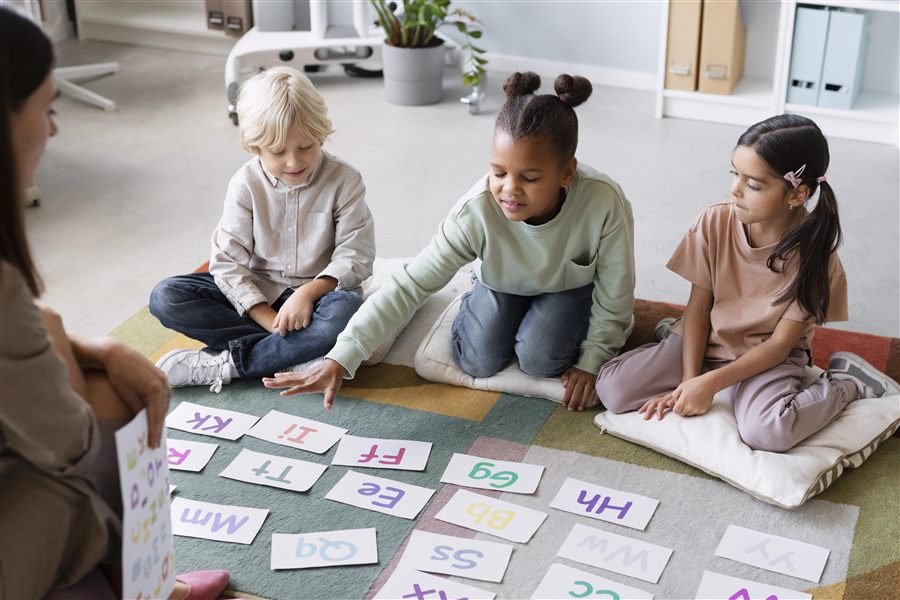 Educator working closely with students on language skills